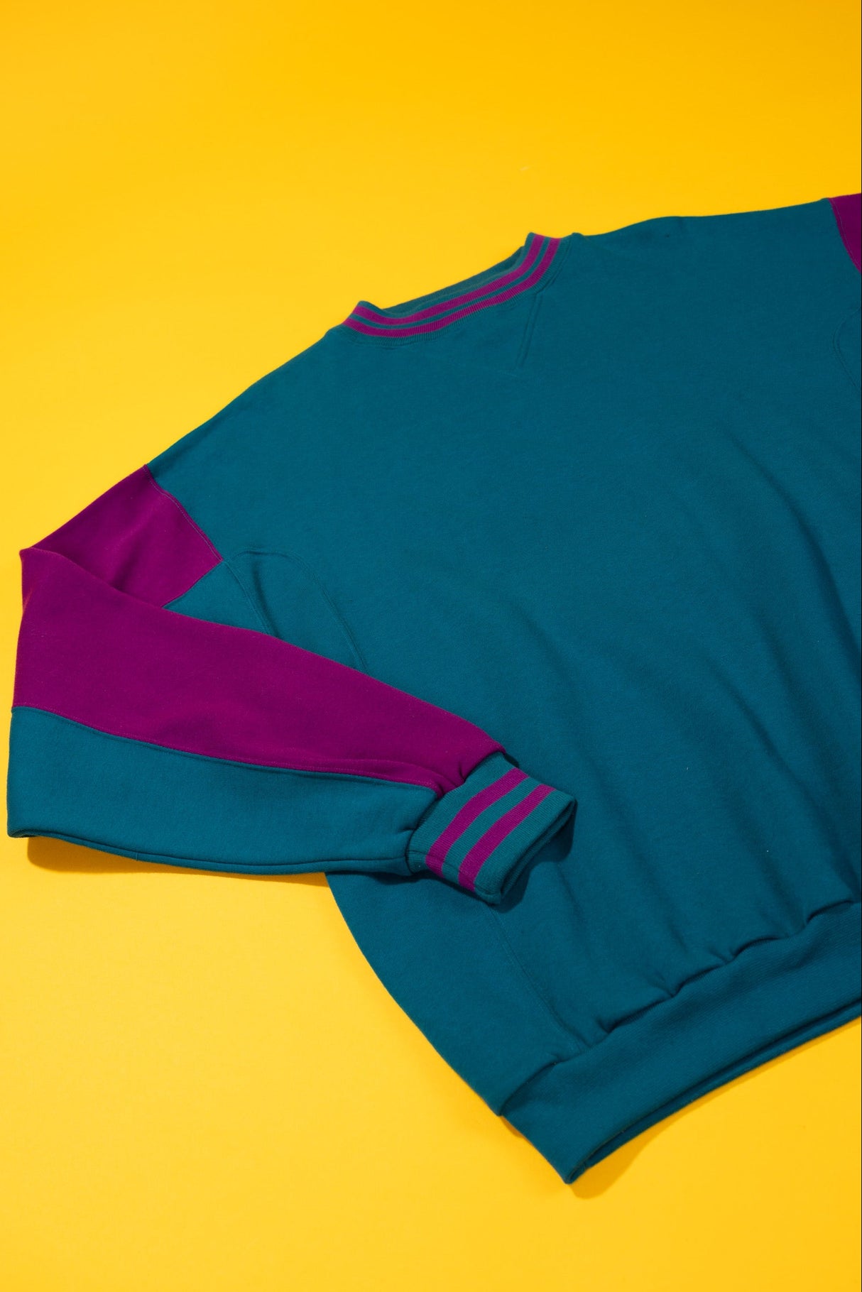 vintage teal and purple crewneck on a yellow background